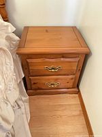 Front view of pine side table showing two drawers and hardware