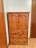 full view of pine highboy dresser against wall