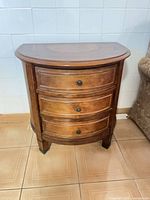 Front view of demilune side table showing three drawers and hardware