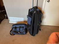 Large rolling duffel and smaller carry bag side by side