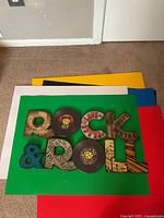 Front view of metal wall plaque showing ROCK & ROLL design with vinyl record motifs