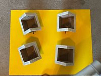 Underside view of four small wooden birdhouses showing unfinished wood bases