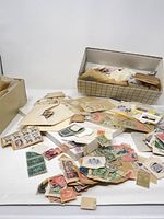 Overhead view of loose stamps spread on table with two boxes holding envelopes and packets