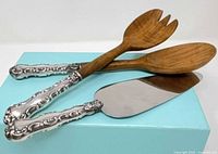 Three serving utensils showing wood ends and sterling handles