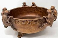 Side view showing six monkeys on rim, Greek key band, bronze finish