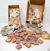 Two cardboard boxes and scattered bundles of used stamps