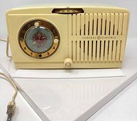 Front view showing clock, radio dial, speaker grille, power cord