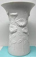 Front view of white Kaiser porcelain vase with relief flowers and butterfly