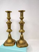 Front view showing both brass candlesticks standing on bases