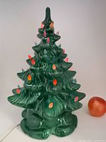 Front view of green glazed ceramic Christmas tree with multicolored bulbs
