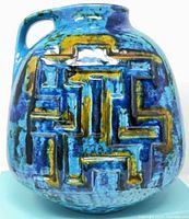 front view showing turquoise/royal blue glaze and raised geometric design