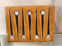 Front of tan rectangular pottery vase with vertical dark stripes and circular accents