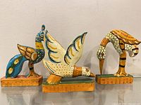Front view of three wooden bird figurines