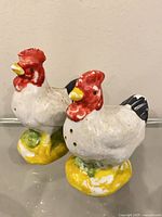 Front view of both ceramic rooster and hen shakers
