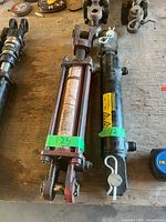 Red used 2.5" bore cylinder and black new 2" bore cylinder side by side on workbench