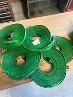 Five coiled green hoses on tabletop
