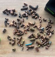 overview of assorted copper fittings spread on work surface with toolbox in view