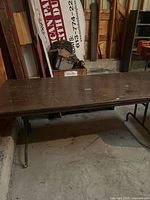 Full view of the brown folding table with metal legs