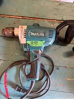 Left side view of Makita DS4012 spade-handle drill showing chuck, body and cord