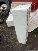 Front view of rectangular white styrofoam block standing upright on gravel