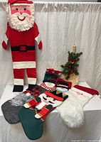 All items grouped: Santa wall hanging, five stockings, wicker chimney boot