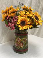 Front view of sunflower arrangement in green painted wooden vase