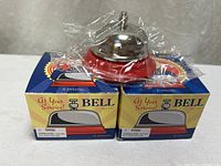 Two boxed Schylling desk bells, one bell shown unboxed still wrapped