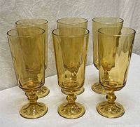 Front view of all six amber pedestal goblets