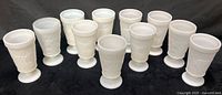 Front view of all 11 milk glass goblets lined up