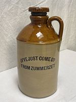 Front view of two-tone stoneware jug showing printed lettering
