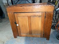 Front view of pine dry sink cabinet showing door, knobs, surface wear