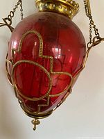 close-up of cranberry glass globe with brass strapwork