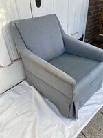 Front left view of blue upholstered armchair without seat cushion