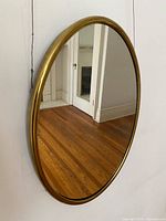 Front view of oval brass mirror showing reflection and frame