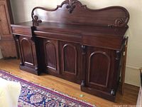 Full front view of mahogany sideboard showing shield back and cabinets