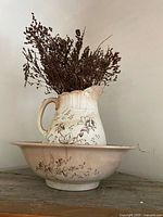 Pitcher in basin with dried flowers showing overall form and floral pattern