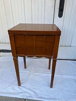 Front view of closed wood sewing cabinet