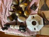 Mixed hardware on towel: brass door knobs, porcelain knob, triangular brass hinges, barrel latch, porcelain octagonal light base