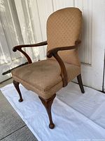 Three-quarter side view of chair showing overall form, upholstery, wooden frame and cabriole legs