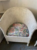 Close-up of one white wicker chair front and cushion
