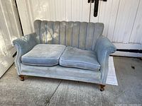Front view of blue velour channel-tufted loveseat with two cushions