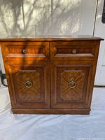 Front view showing double doors and drawers with brass pulls