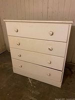 Front view of white 4-drawer dresser showing all drawers closed