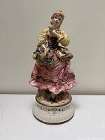 Full view of hand-painted porcelain Victorian lady figurine on pedestal base