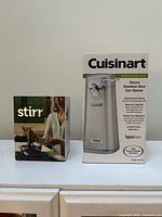 Retail boxes of Cuisinart can opener and Uutensil Stirr stirrer side by side
