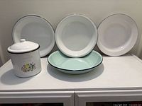Plates and lidded canister grouped on cabinet