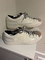 Side view of both shoes showing white leather, shearling toe, silver laces, perforated side panel