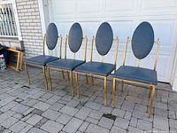 Four gold metal frame dining chairs with blue vinyl upholstery, front view