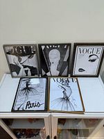 Five framed Vogue prints displayed upright and flat