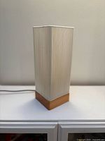 Oblique view showing wood base and off-white ribbed shade